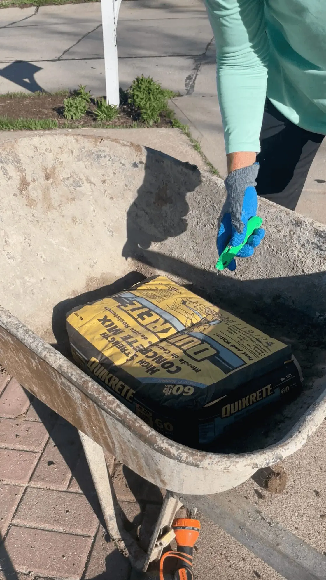 Cutting a bag of concrete with a box knife.